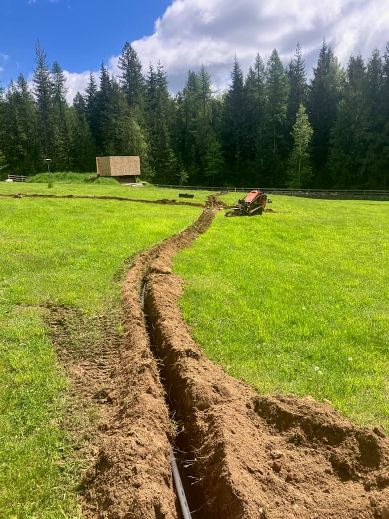 Selkirk Sprinklers crew trenching irrigation pipe with a Ditch Witch